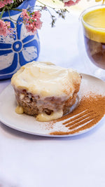 Cinnamon Roll de 185 g con cobertura cremosa, servido en un plato